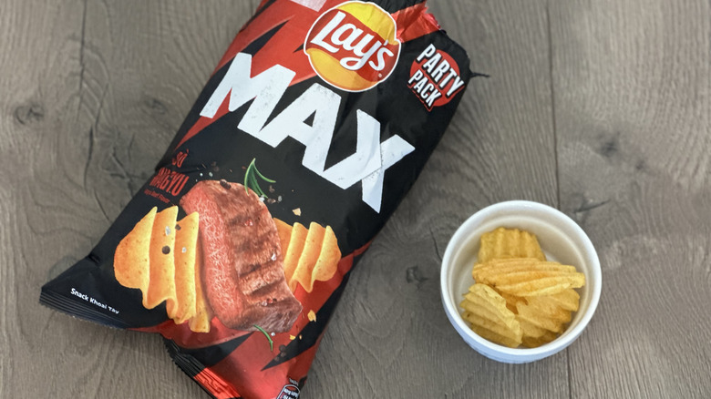 Overhead image of bag of Lay's Wagyu Beef flavored potato chips with small white ramekin filled with chips