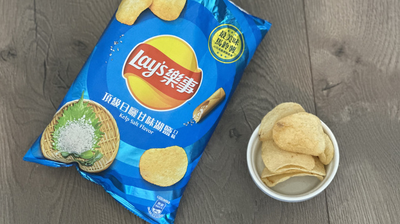 Overhead image of bag of Lay's Kelp Salt flavored potato chips with small white ramekin filled with chips