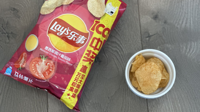 Overhead image of bag of Lay's Mexican Tomato Chicken flavored potato chips with small white ramekin filled with chips
