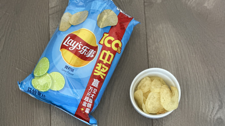 Overhead image of bag of Lay's Lime flavored potato chips with small white ramekin filled with chips