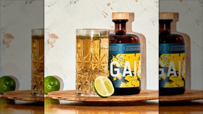 Glass of Feragaia next to Feragaia Free Spirit bottle, lime half in front