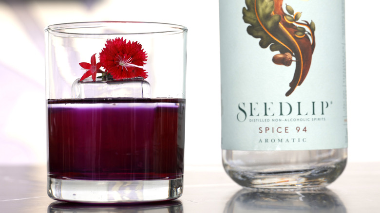 Can of Seedlip 94 next to red drink in glass