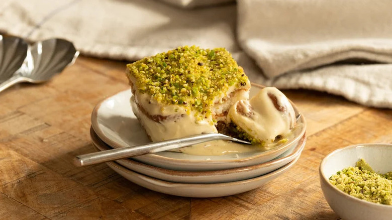 Pistachio Tiramisu on stack of small beige plates