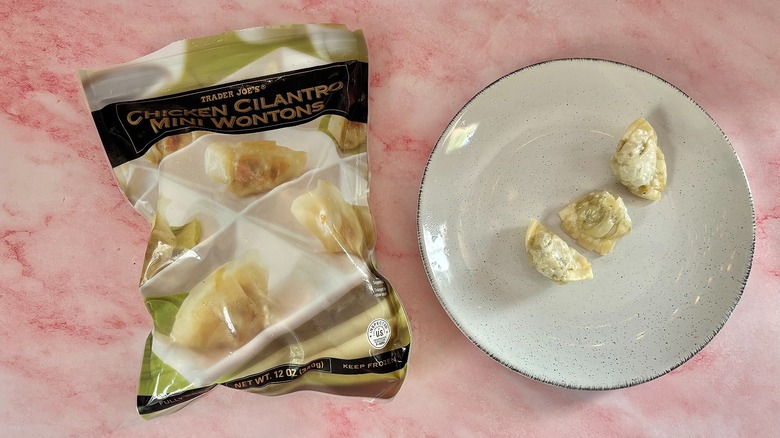 Trader Joe's chicken cilantro mini wontons on plate next to bag on pink marble surface