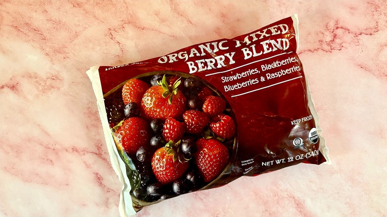 Bag of organic mixed berry blend on pink marble surface