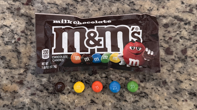 several m&m candies on counter next to package