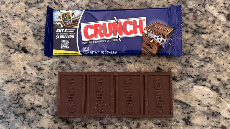 Crunch bar unwrapped on counter beside wrapper