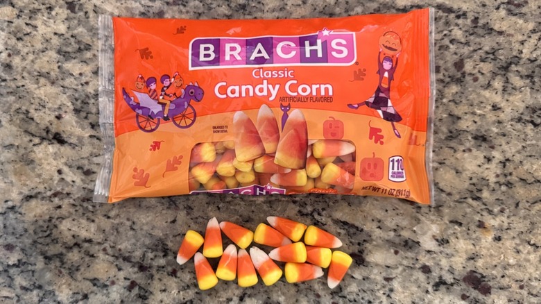 several candy corn pieces on counter beside bag