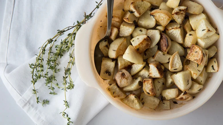 Bowl with herby roasted turnips with a sprig of thyme