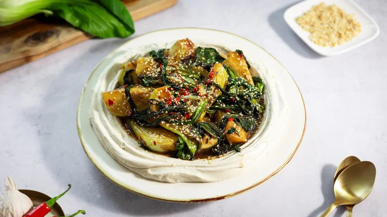 Bowl plated with tofu cream topped with stir-fried bok choy