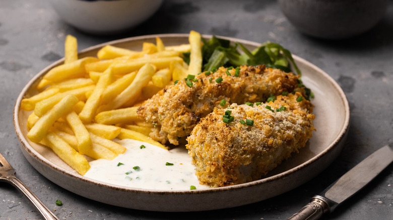 Cornflake-coated chicken on plate with fries and ranch sauce