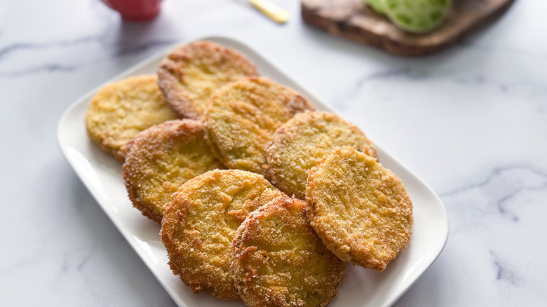 Crispy fried tomato slices on white plate