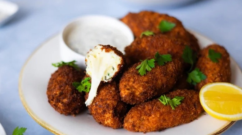 Pile of cheesy croquettes on plate