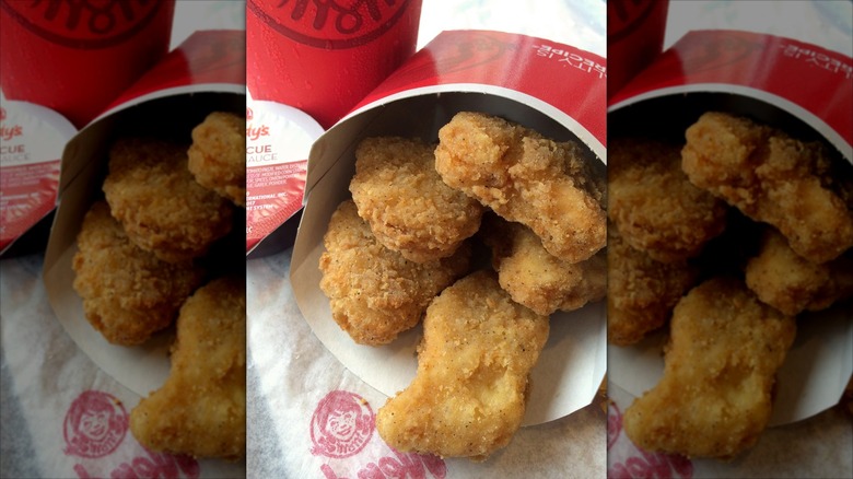Wendy's nuggets spilling out of box near dipping sauce and cup