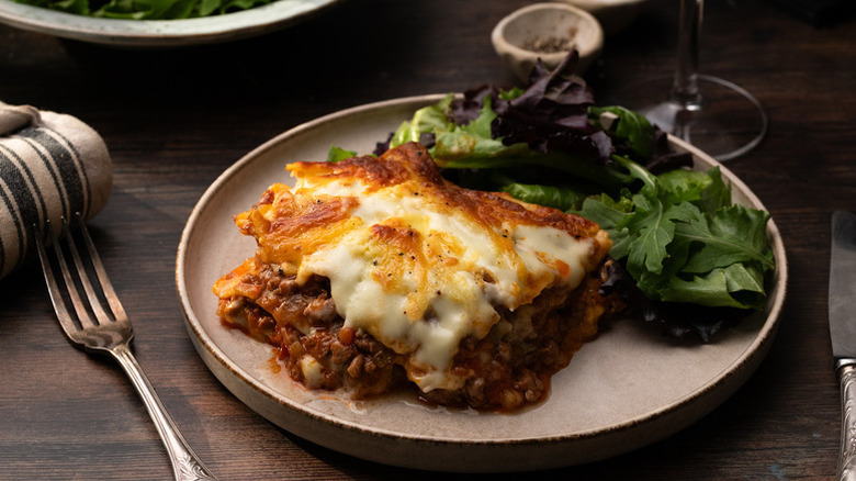 Gluten-free lasagna on plate with leafy side salad