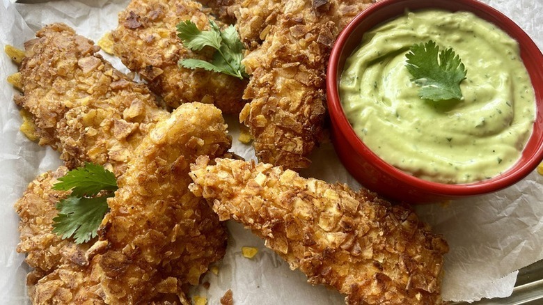 Plantain-crusted chicken fingers with pot of creamy guacamole