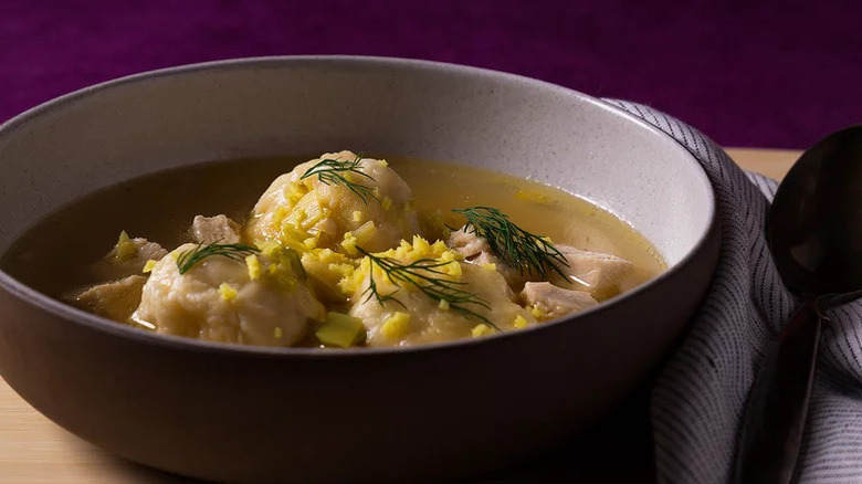 Chicken and Dumplings Soup in grey bowl on purple background
