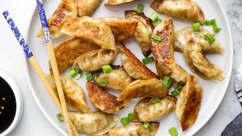 Crispy Vegetable Potstickers on white plate with chopsticks