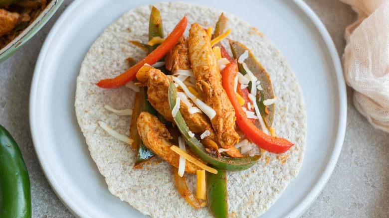 Spicy Chicken Fajitas on tortilla on white plate