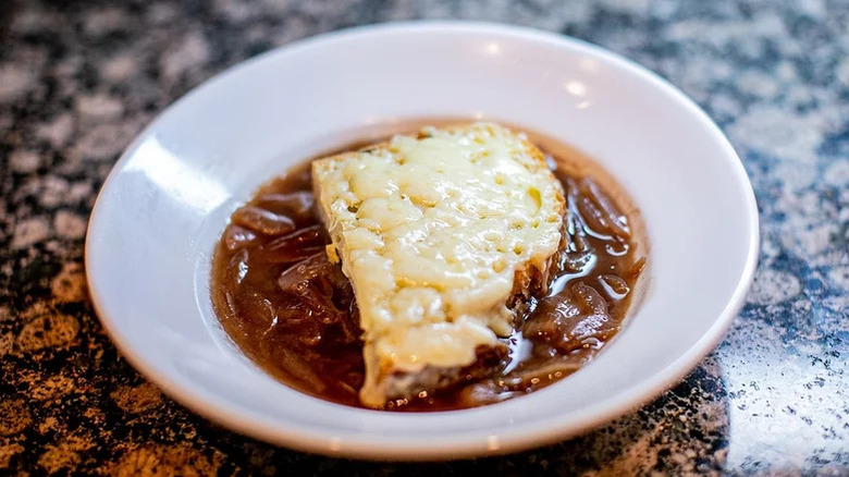 French onion soup in bowl topped with cheese bread