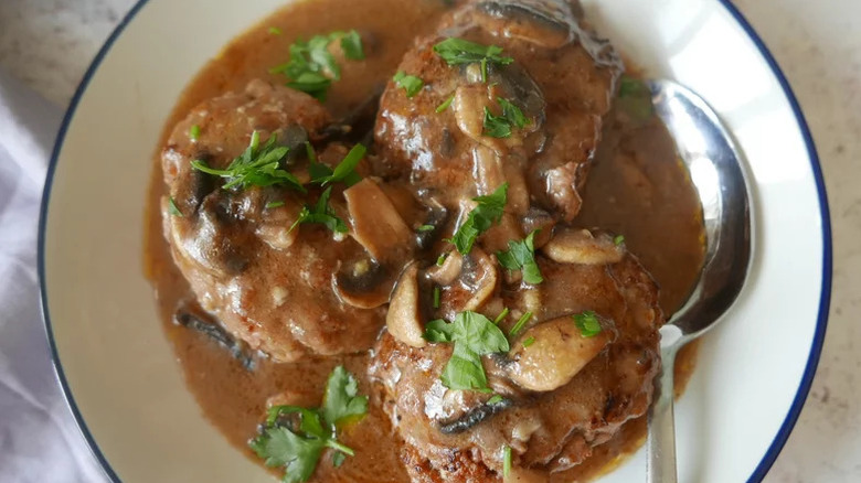 Salisbury steak meal on plate garnished with fresh parsley