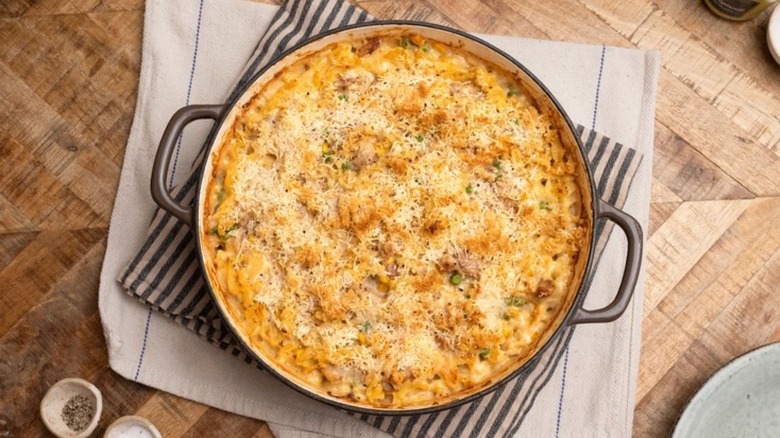 top view of a pot of tuna casserole topped with cheese and served on kitchen towels