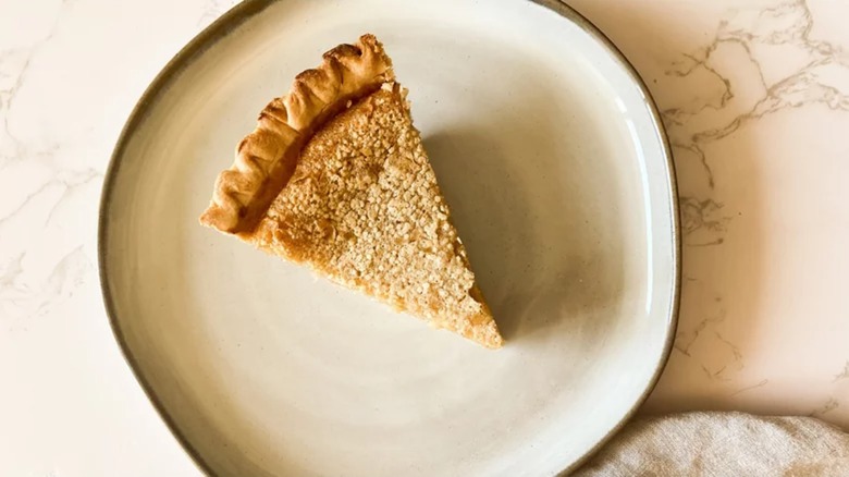 Slice of creamy bean pie on plate on marble counter
