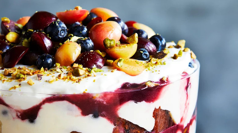 Cherry-pistachio trifle with colorful fruit on top and chopped pistachios