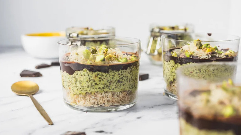Dubai pistachio chia pudding in small glass jars with gold spoon