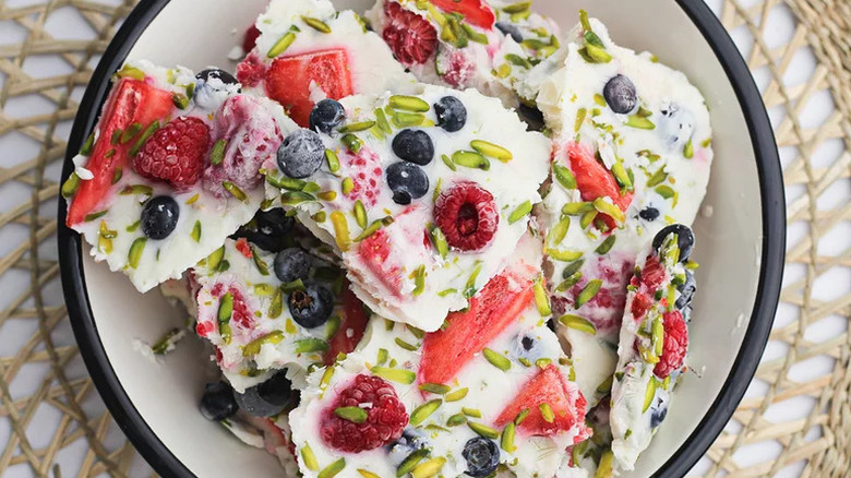 Top view of pieces of frozen yogurt bark in black and white bowl