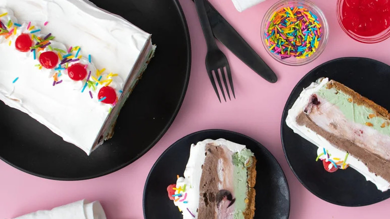 Spumoni-Style Italian Cream Cake on black plates with bowl of sprinkles