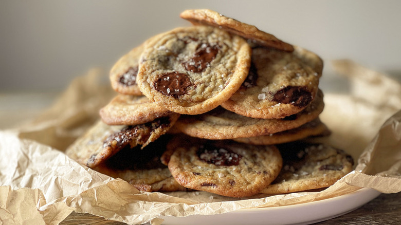 Pile of chocolate chip cookies in parchment-lined plate