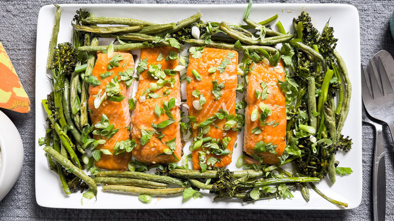 Roasted salmon fillets on plate with broccoli and asparagus