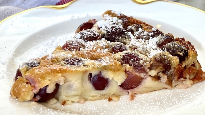 Slice of cherry clafoutis dusted with powdered sugar