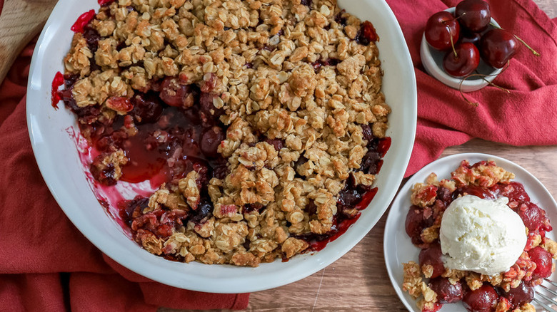Cherry crisp in baking dish and served onto small plate with ice cream