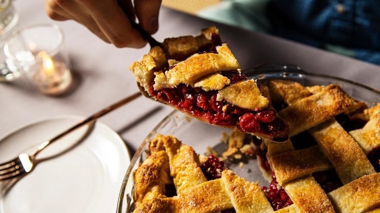 Lifting slice of cherry pie from serving plate