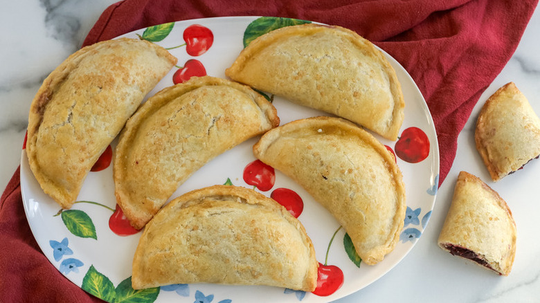 Cherry empanadas on a cherry-patterned serving plate