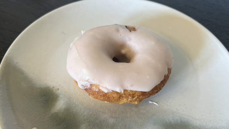 Duck Donuts strawberry iced donut on plate.