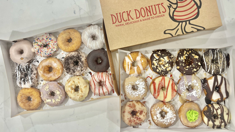 Two dozen Duck Donut flavors in boxes.