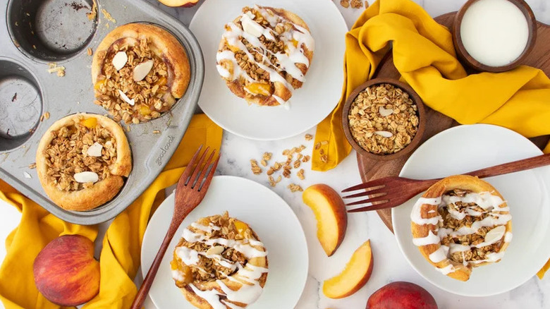 Peach cobbler cinnamon rolls in baking pan and served onto plates