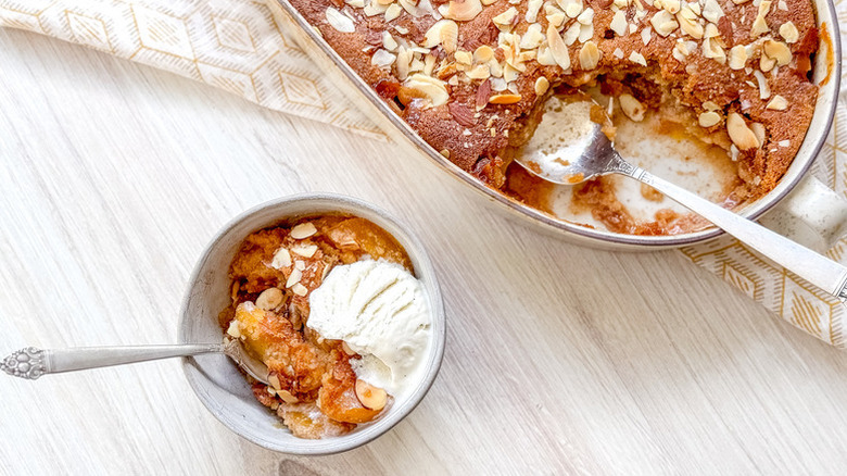 Peach cobbler served from baking dish into bowl