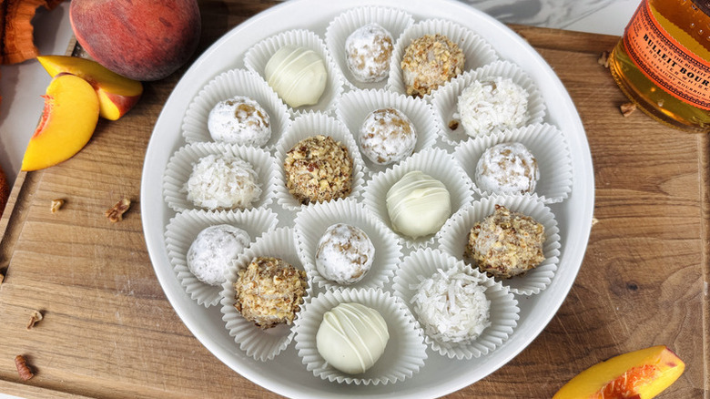 Peach truffles in paper cases on white plate