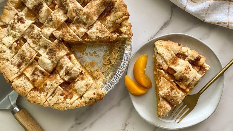 Slice of lattice-topped peach pie served onto plate
