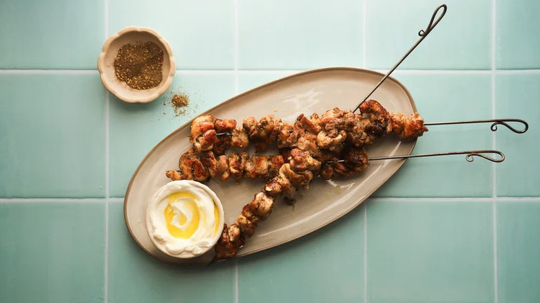 Grilled Za'atar Chicken Skewers on beige plate with sauce