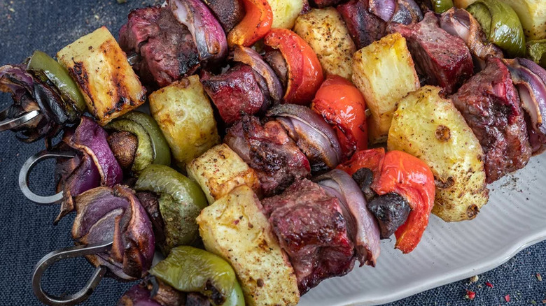 Smoked Steak Kabobs on metal skewers on white plate