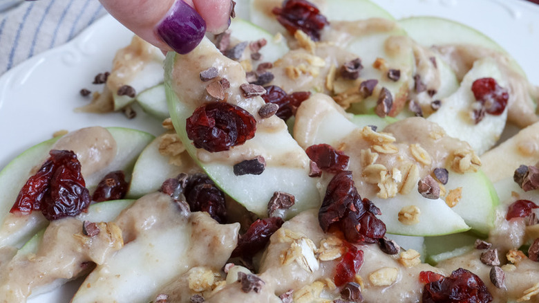 Apple nachos topped with date caramel, dried cranberries, and granola