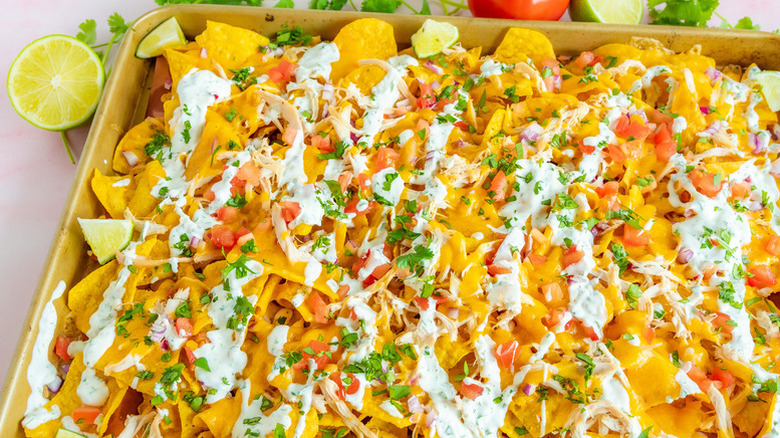 Sheet pan nachos with sour cream and chopped cilantro