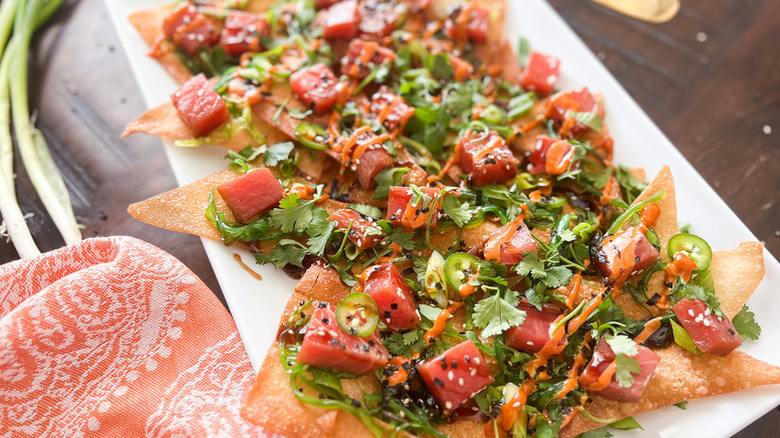 Poke-style ahi tuna nachos on white platter, made with crispy wonton wrappers