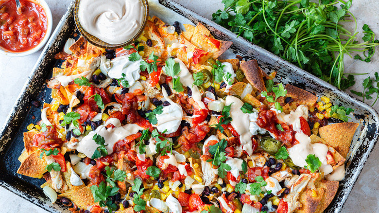 Chicken nachos in sheet pan with spicy mayo and cilantro