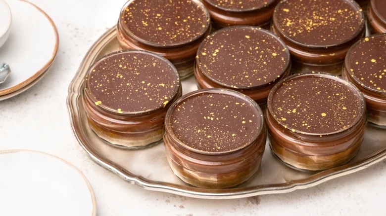 Chocolate cheesecake pots arranged on a gold tray